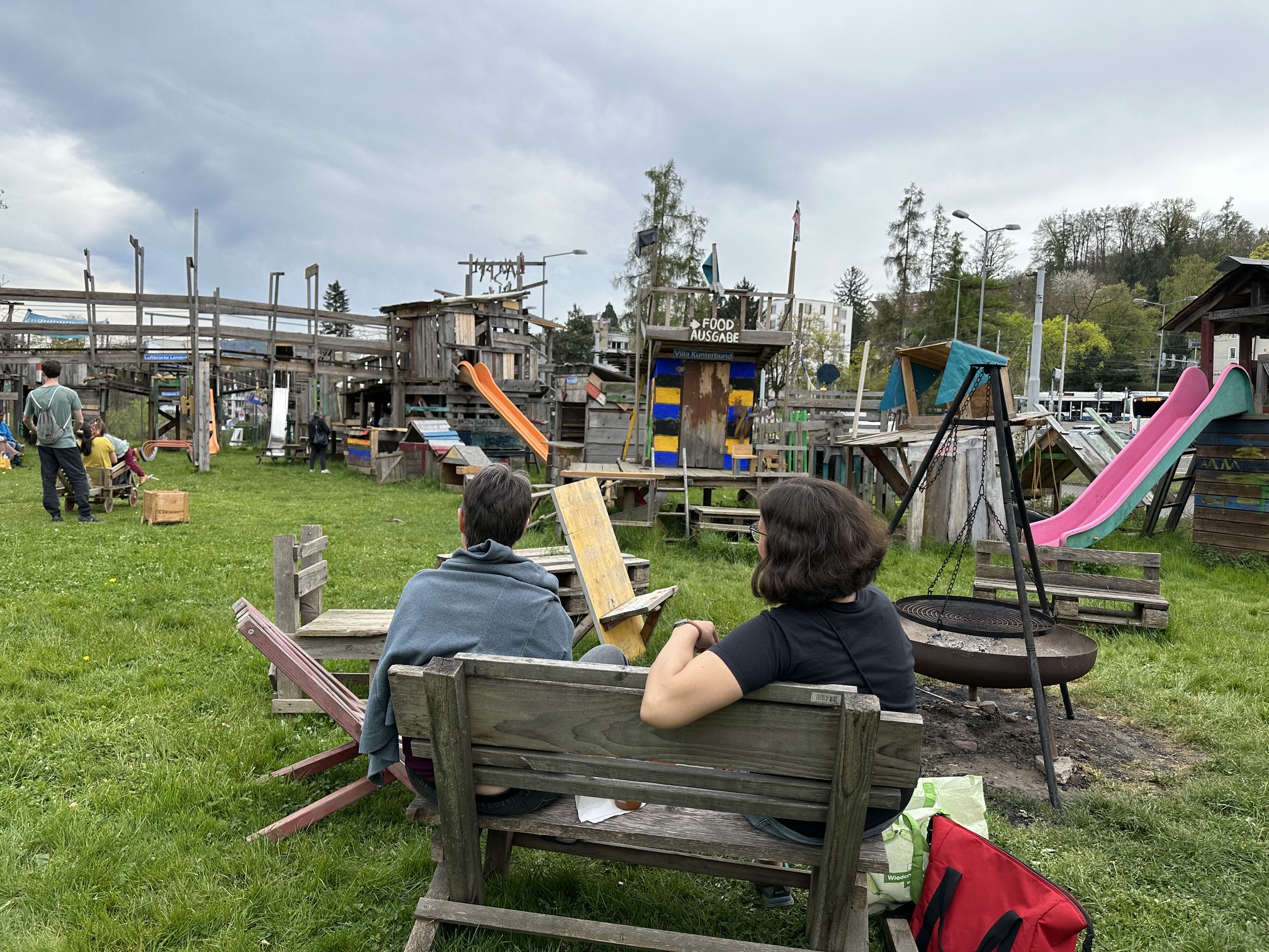 Blick über den Bauspielplatz mit Hütten, Rutschen und Feuerstelle
